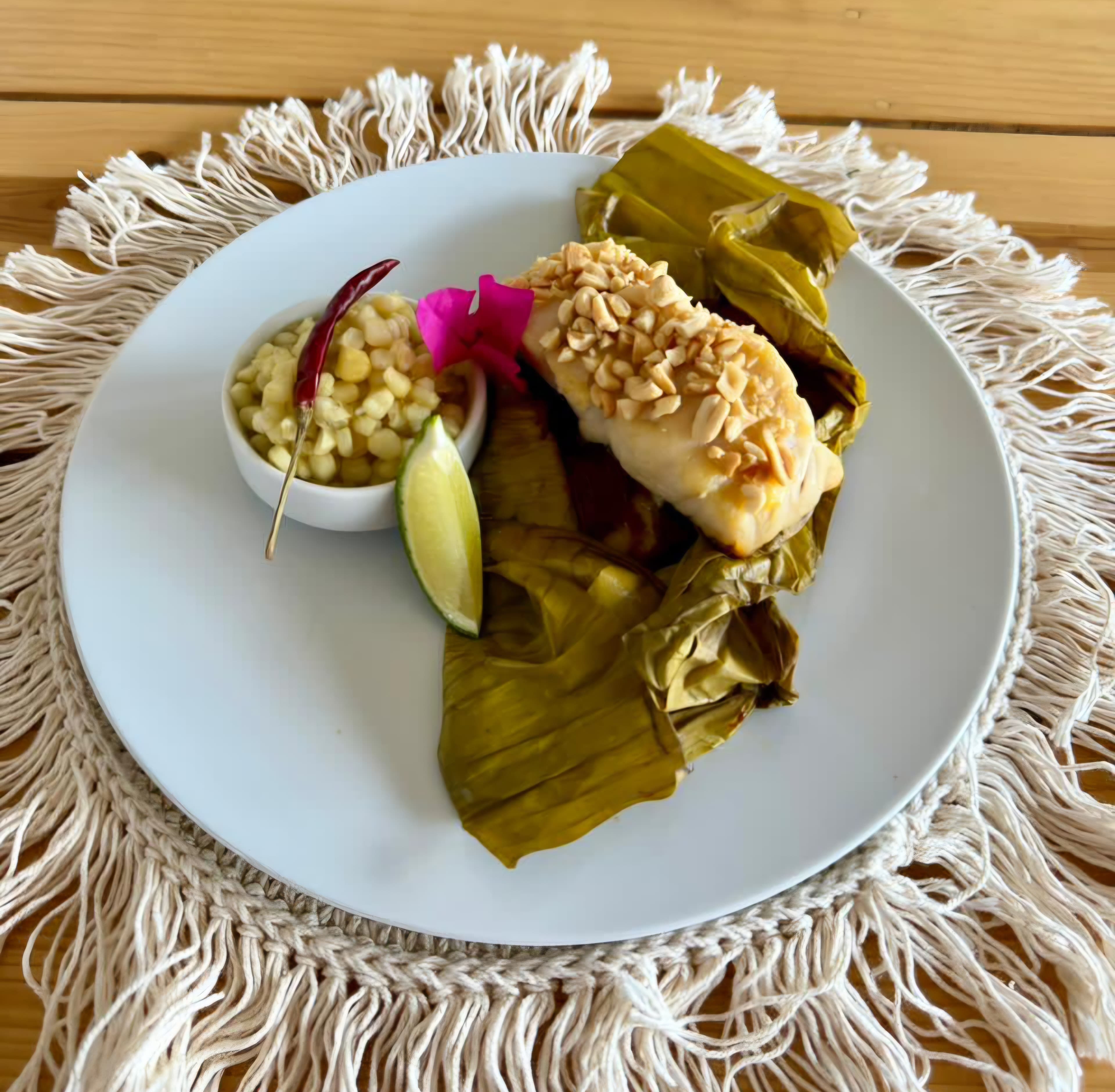 White fish fillet wrapped and steamed in a corn leaf, served with mole coloradito and esquites.